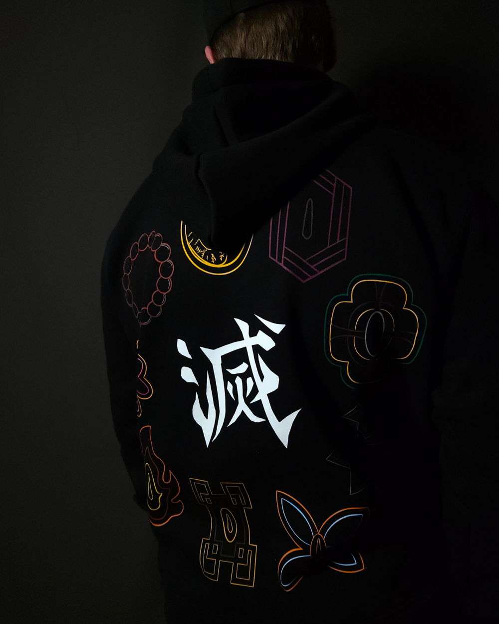 Anime-inspired apparel featuring bold back artwork, worn by a model in a dark studio setting – from a South African anime clothing brand.