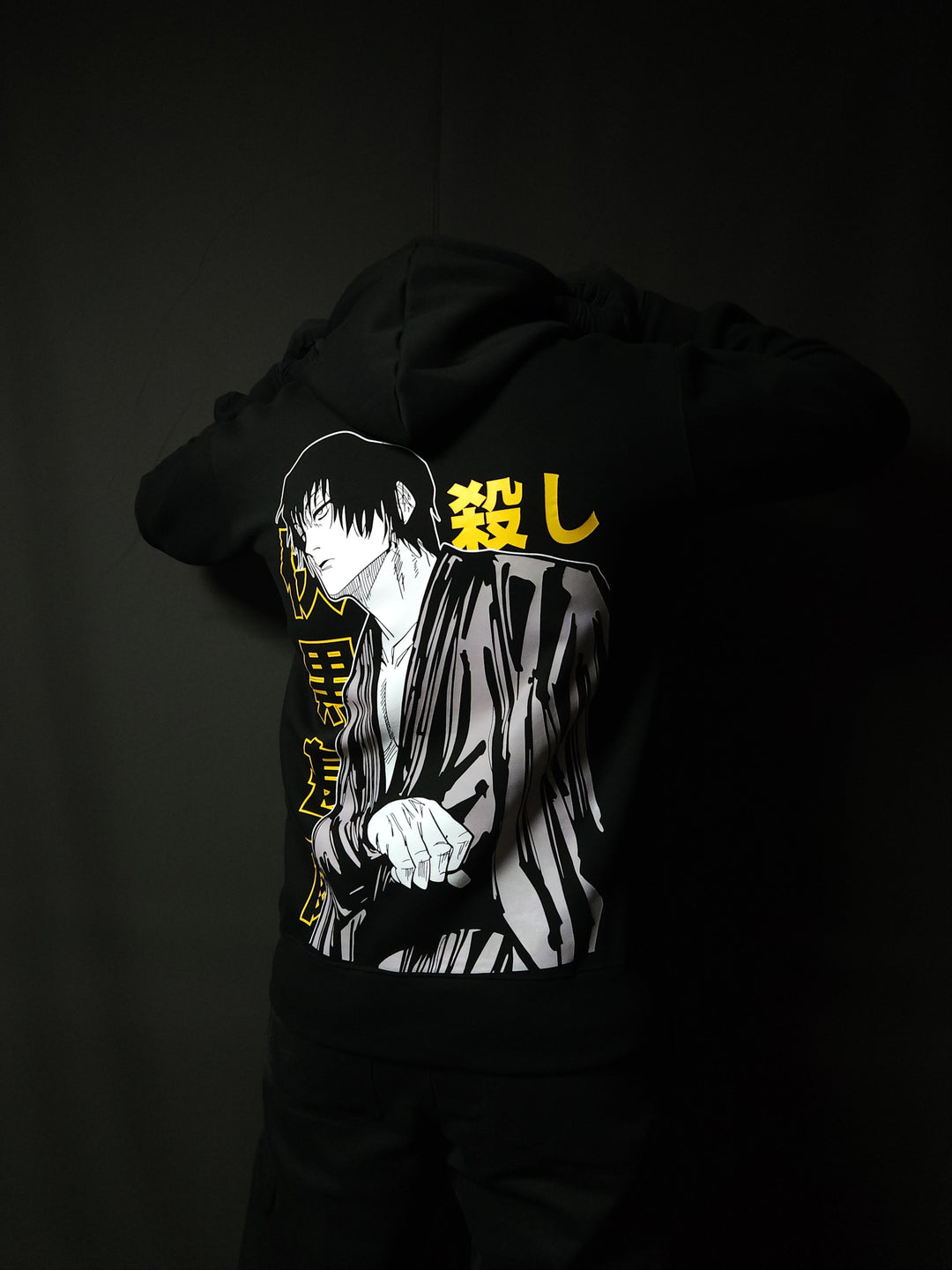 Anime-inspired apparel featuring bold back artwork, worn by a model in a dark studio setting – from a South African anime clothing brand.