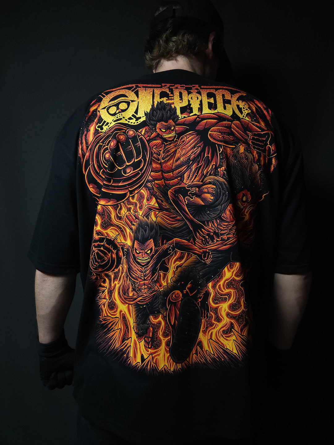 Anime-inspired apparel featuring bold back artwork, worn by a model in a dark studio setting – from a South African anime clothing brand.